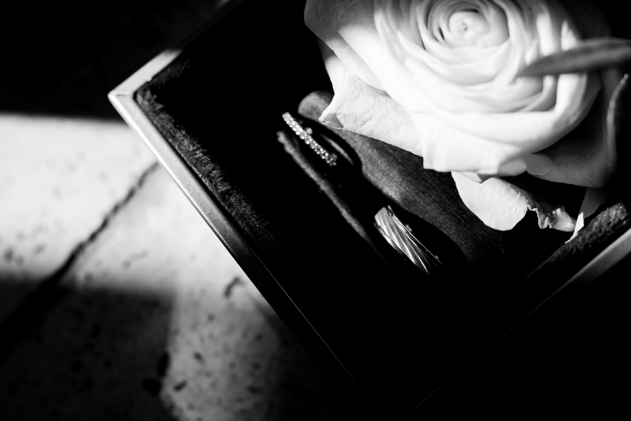 Alliances et rose en noir et blanc lors d'un mariage au Château de Collias