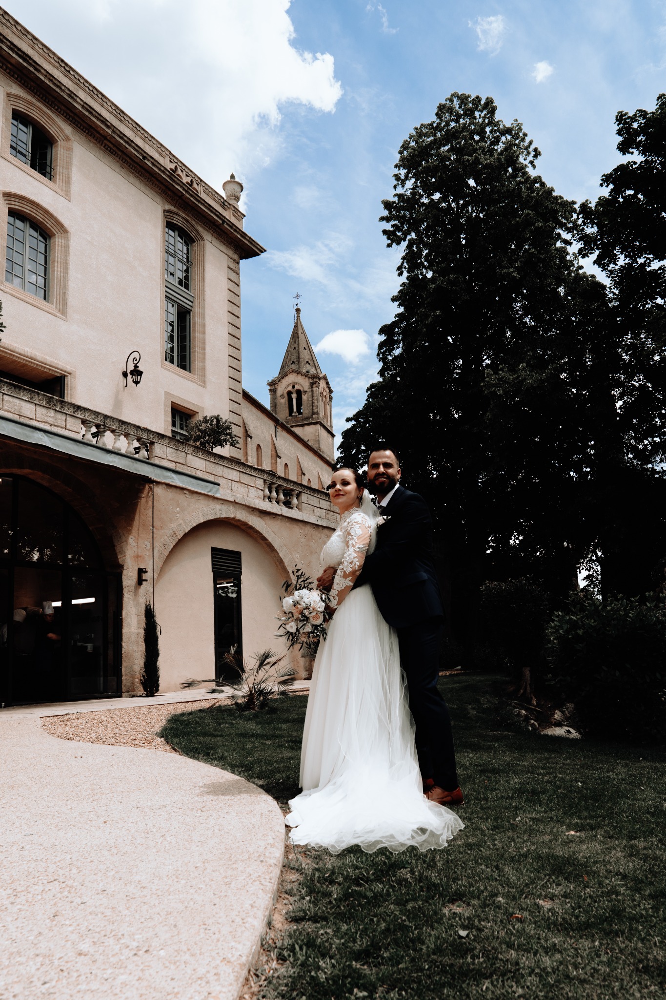 Couple de mariés devant la façade du Château de Collias