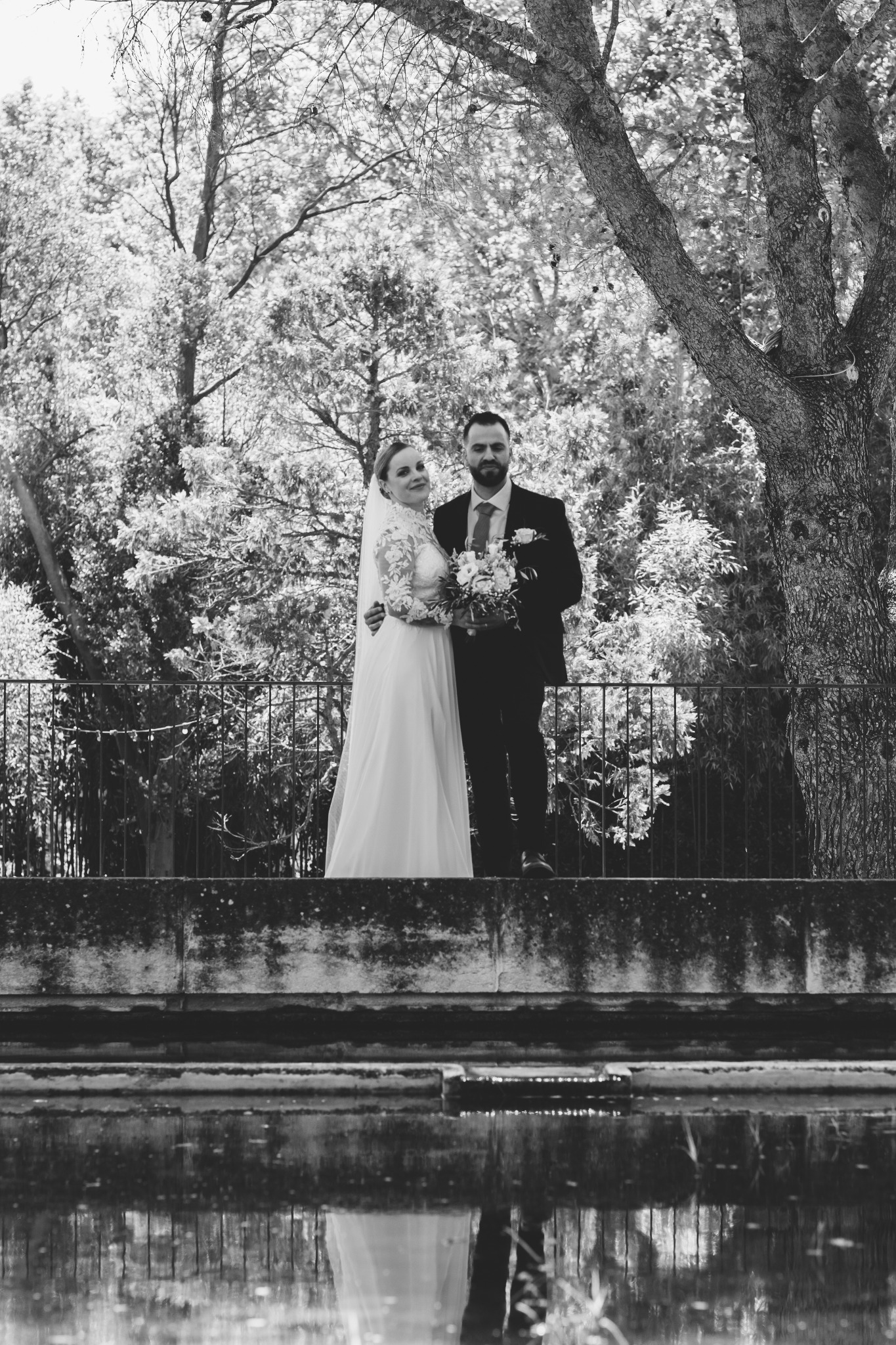 Reflet des mariés dans le bassin du Château de Collias en noir et blanc