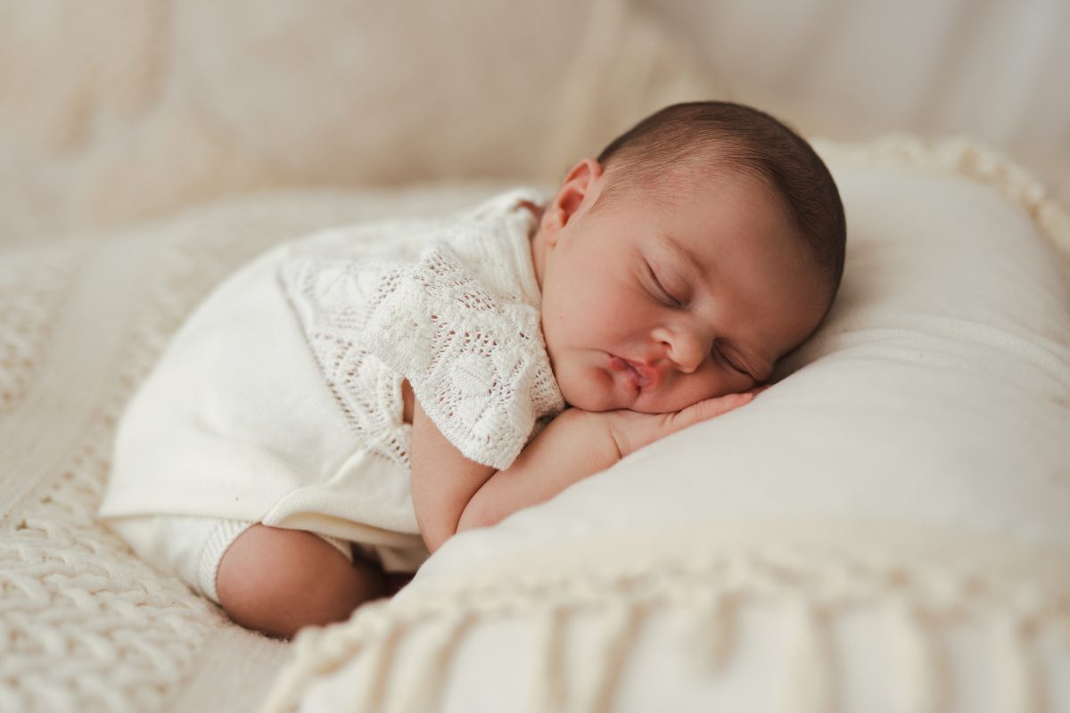 Bébé endormi sur un coussin en dentelle claire