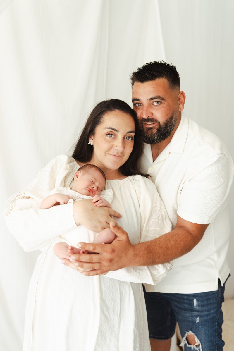Portrait vertical de jeunes parents avec leur bébé