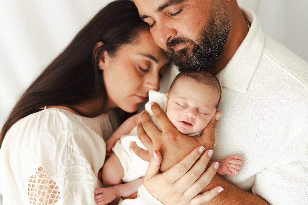 Parents entourant leur nouveau-né dans leurs mains
