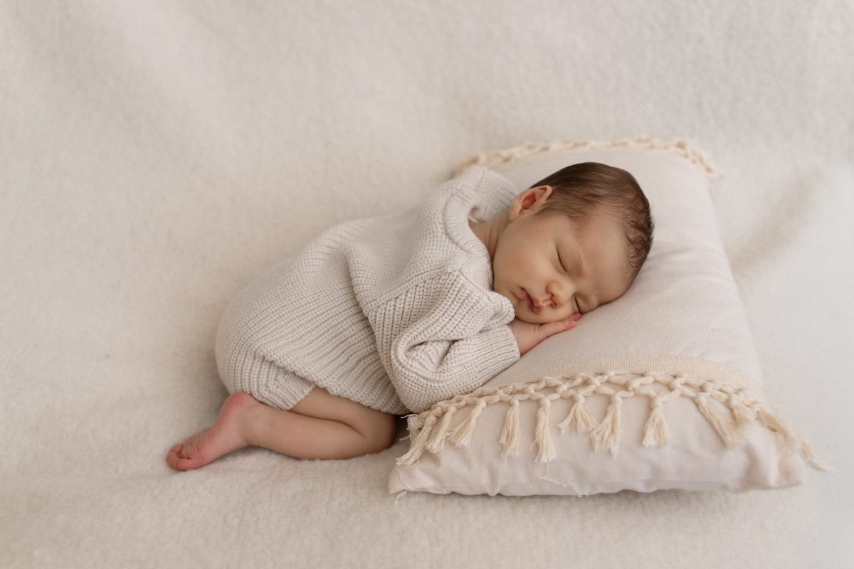 Bébé endormi sur un coussin clair