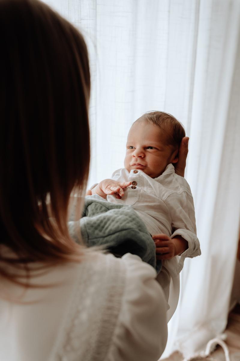 Une maman regarde son bébé éveillé dans ses bras