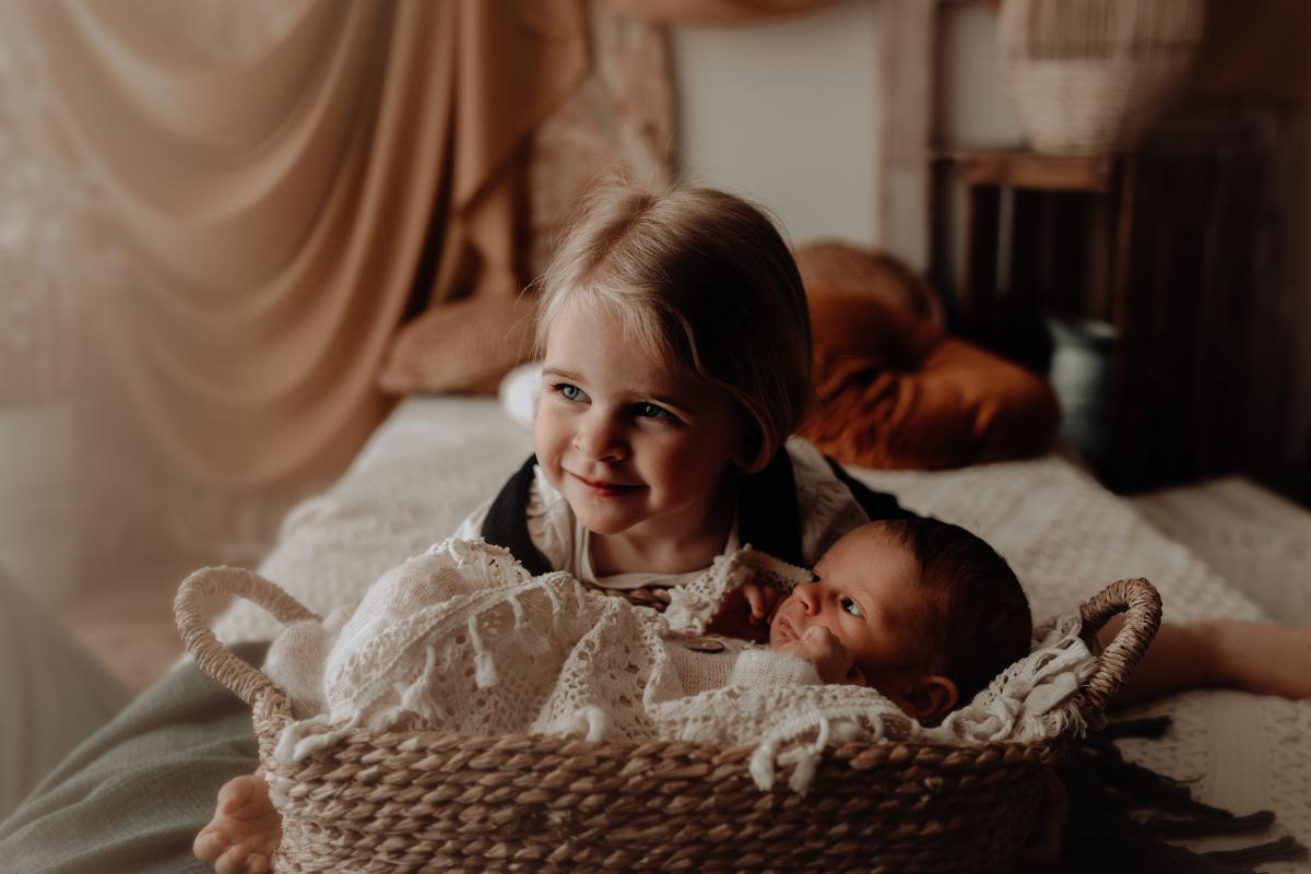 Grande sœur souriante auprès de son nouveau petit frère