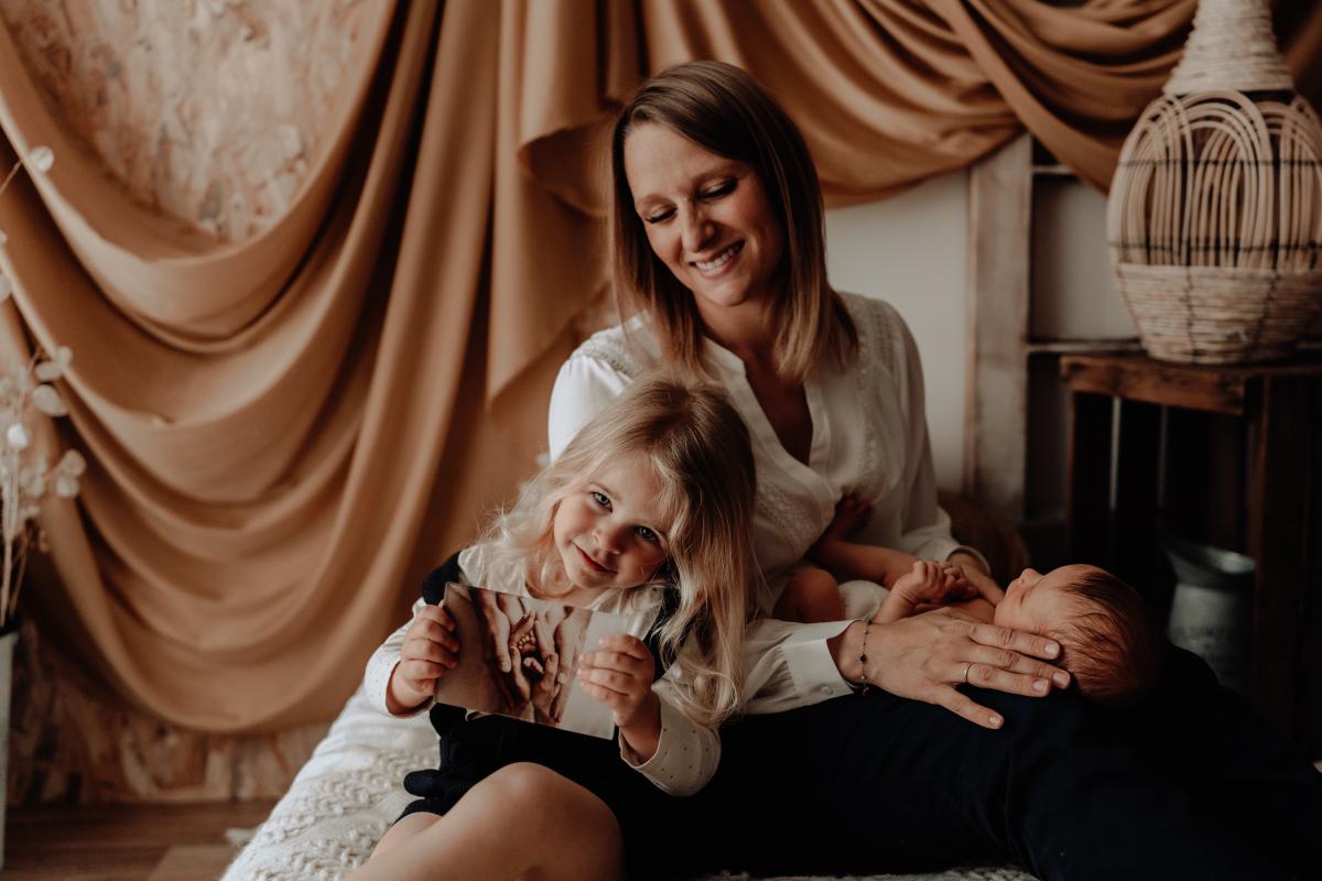 Maman avec ses deux enfants sur un lit