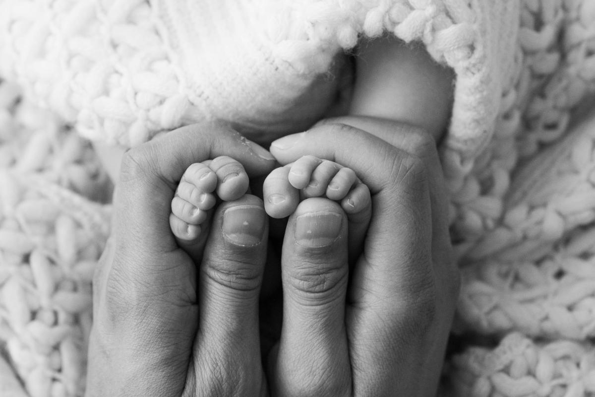 Petits pieds d’un nouveau-né dans les mains