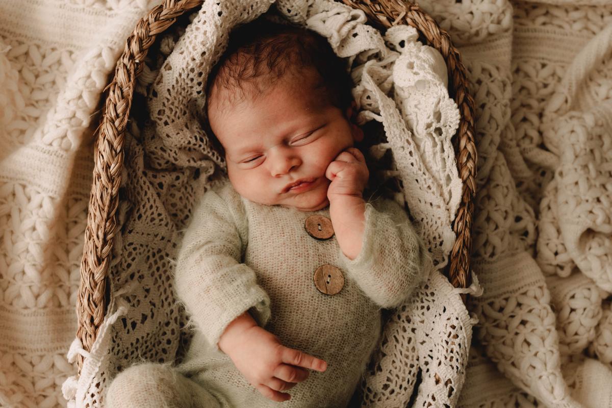 Nouveau-né endormi dans un panier en fibres naturelles