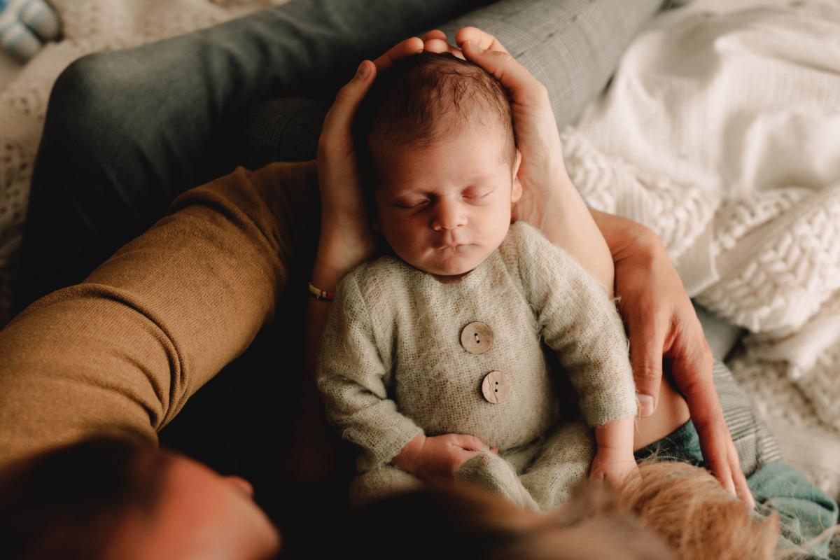 Bébé endormi dans les mains de sa famille